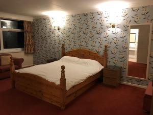 布雷得佛海菲尔德酒店的一间卧室配有木床和蓝色及白色壁纸