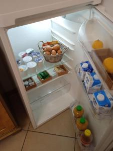 特伦托伊甸园住宿加早餐旅馆的开放式冰箱内有鸡蛋和食物