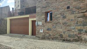 新普罗恩萨Casa Resineiro com Garagem e Terraço的一座砖砌建筑,设有车库门和阳台