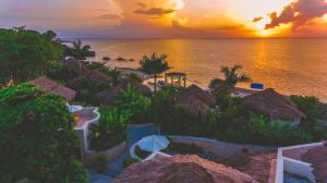 尼格瑞尔Ocean Cliff Hotel Negril Limited的日落时分在度假村欣赏海滩美景