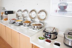 广岛广岛和平公园经济型酒店的厨房柜台上放着许多盘子的食物