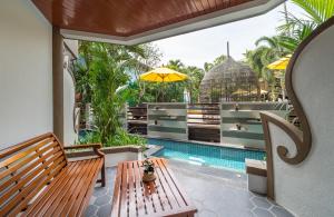 奥南海滩Aonang Princeville Villa Resort & Spa - GHA WellHotel-Halal Certified, Krabi, Thailand的一个带长凳和游泳池的庭院