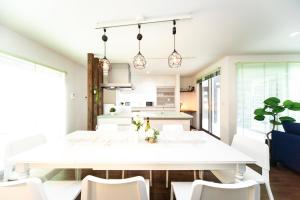 今津Shiga Lakeside Villa的厨房以及带白色桌椅的用餐室。