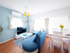 札幌Sapporo - Apartment - Vacation STAY 7940的客厅配有蓝色的沙发和桌子