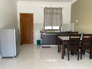 珍南海滩Laura Guest House Langkawi的厨房配有桌子和冰箱