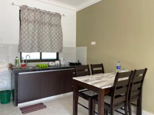 珍南海滩Laura Guest House Langkawi的厨房配有桌椅和水槽。