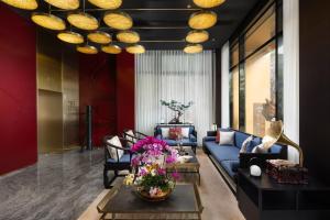 广州广州永庆坊瞻云精选酒店的客厅配有蓝色的沙发和带鲜花的桌子