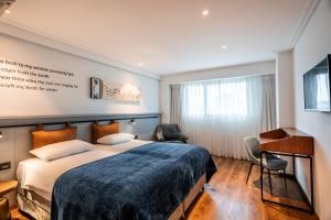 拉马特甘Roxon Urban Ramat Gan的配有一张床和一张书桌的酒店客房