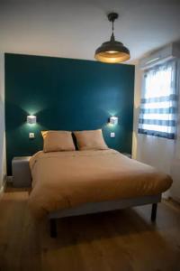图尔LES 2 LIONS moderne confort proche transports的一间卧室配有一张大床和绿色床头板