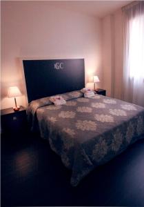 里米尼朱利奥塞萨雷酒店的酒店客房,配有一张床和两盏灯