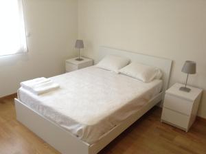 蓬塔德尔加达Ramalho Apartments T3 Cidade Ponta Delgada的一间卧室配有白色床和2个床头柜