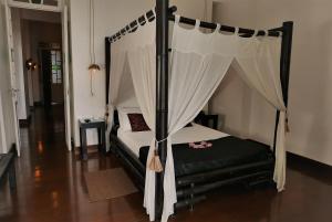 萨尔瓦多亚兰雅美精品酒店的一间卧室配有一张带天蓬的黑色床