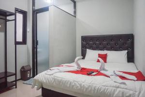 RampalRedDoorz Plus @ Kalpataru的一间卧室配有一张带红色和白色床单的大床