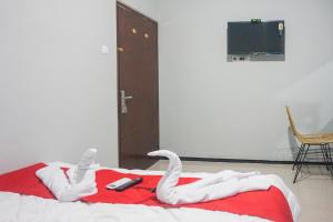 RampalRedDoorz Plus @ Kalpataru的一张床上有两只白色天鹅
