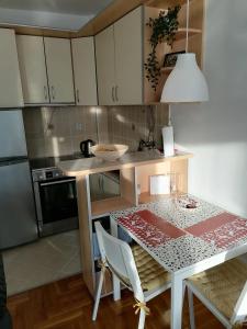 斯梅代雷沃ANKA apartman的一间带桌子的小厨房和一间餐厅