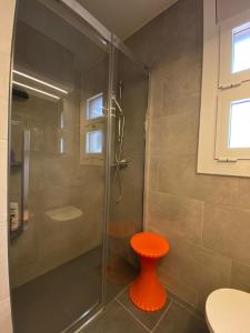 科尔百托Casa acogedora al pie de Montserrat的浴室里设有橙色凳子和淋浴