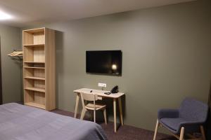 博尔加内斯Basalt Hotel的客房设有1张床、1张桌子和1台电视。