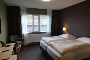 博尔加内斯Basalt Hotel的酒店客房设有两张床和窗户。