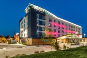 阿林顿Aloft Dallas Arlington Entertainment District的酒店大楼前面有粉红色的灯光