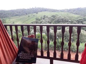 PilõesChalé com Vista Privilegiada的坐在山景阳台上的书