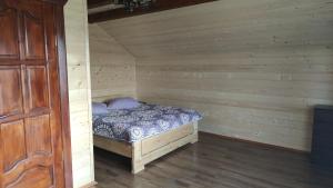 沃罗赫塔Приватна садиба "Гереджука"的木制客房内的一间卧室,配有一张床