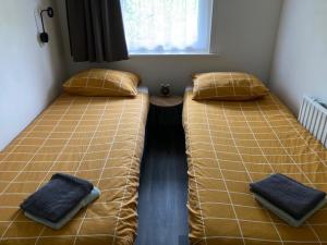 SchoonlooDe Deelderij的两张睡床彼此相邻,位于一个房间里