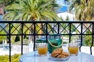 普里诺斯Eleani Hotel的一张桌子,上面放着两杯橙汁和一碗饼干