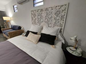 Rémiré"Koko Lodge" Lodge paisible avec terrasse, jardin et piscine的卧室配有带枕头的大型白色床