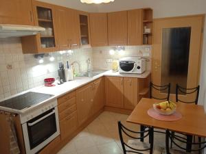 杰尔Family apartment-családias hangulat的厨房配有木制橱柜、桌子和微波炉