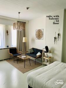 克诺克－海斯特Studio Heyst的一间卧室配有一张床、一把椅子和一张沙发