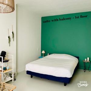 克诺克－海斯特Studio Heyst的一间卧室配有一张带绿色墙壁的床