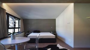克里索洛La Meira Sermig Casa Ferie的一间卧室配有一张床、一张桌子和一个窗户。