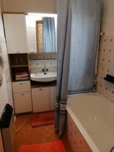 穆赫克雷斯的艾根Appartmenthaus Kern的一间带水槽、浴缸和镜子的浴室