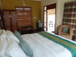 KumguriMusa Jungle Retreat的卧室配有带蓝色枕头的大型白色床