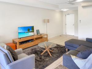 耐莉湾海滨14号公寓的客厅配有沙发和桌子上的电视