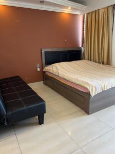 香港海景度假屋的一间卧室配有一张床和一个黑色的搁脚凳