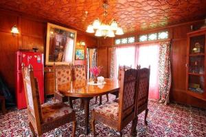 斯利那加纳基恩百合船屋酒店的一间带木桌和椅子的用餐室