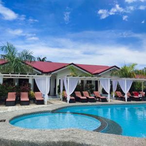 莫阿尔博阿Garden Village Resort的一座带椅子的度假游泳池以及一座建筑