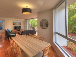 霍斯舒湾Maggies Beachfront Apartment 2的用餐室和带木桌的客厅