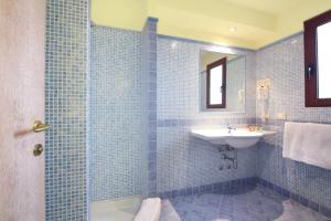 默塔玛丽亚Hotel Sa Pedra的蓝色瓷砖浴室设有水槽和淋浴