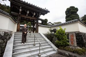 身延宿坊 端場坊｜Temple Hotel Habanobo的站在寺庙楼梯上的男人