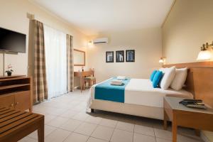 斯卡拉埃雷索Aeolian Village Beach Resort的酒店客房配有一张床铺和一张桌子。