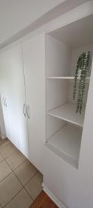 东伦敦StayMore的配有白色橱柜和绿色植物的衣柜