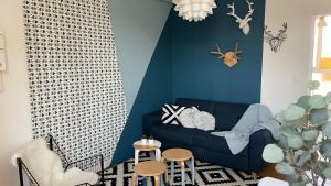 兰斯Le Grand Est Scandinave, centre ville, proche cathédrale的客厅设有蓝色的沙发和蓝色的墙壁
