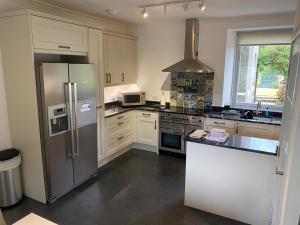 奈斯桥Granite Cottage的厨房配有不锈钢冰箱和炉灶。