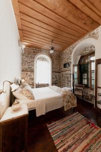 纳夫普利翁Rigas Pension Nafplio的一间卧室设有两张床和石墙
