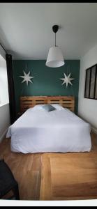 AumontLa tête dans les étoiles的卧室配有一张白色大床,墙上挂着星星