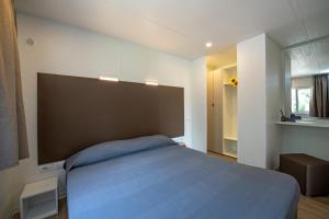 莫尼加Camping Porto srl的卧室设有一张蓝色大床和一扇窗户。