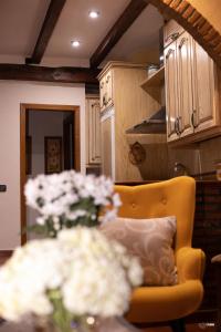 赫尔特CASA RURAL EL PIÑON的厨房配有黄色椅子和花瓶