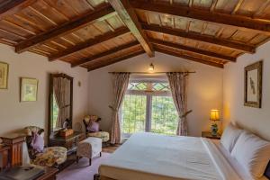拉姆格尔Seclude Ramgarh Taradale的一间卧室设有一张大床和一个窗户。
